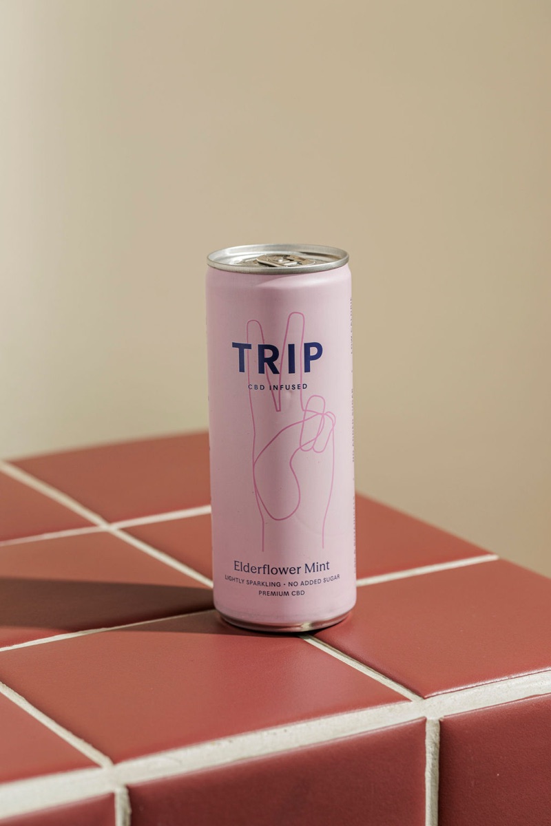 TRIP CBD Elderflower Mint can on the burgundy tile plinth.