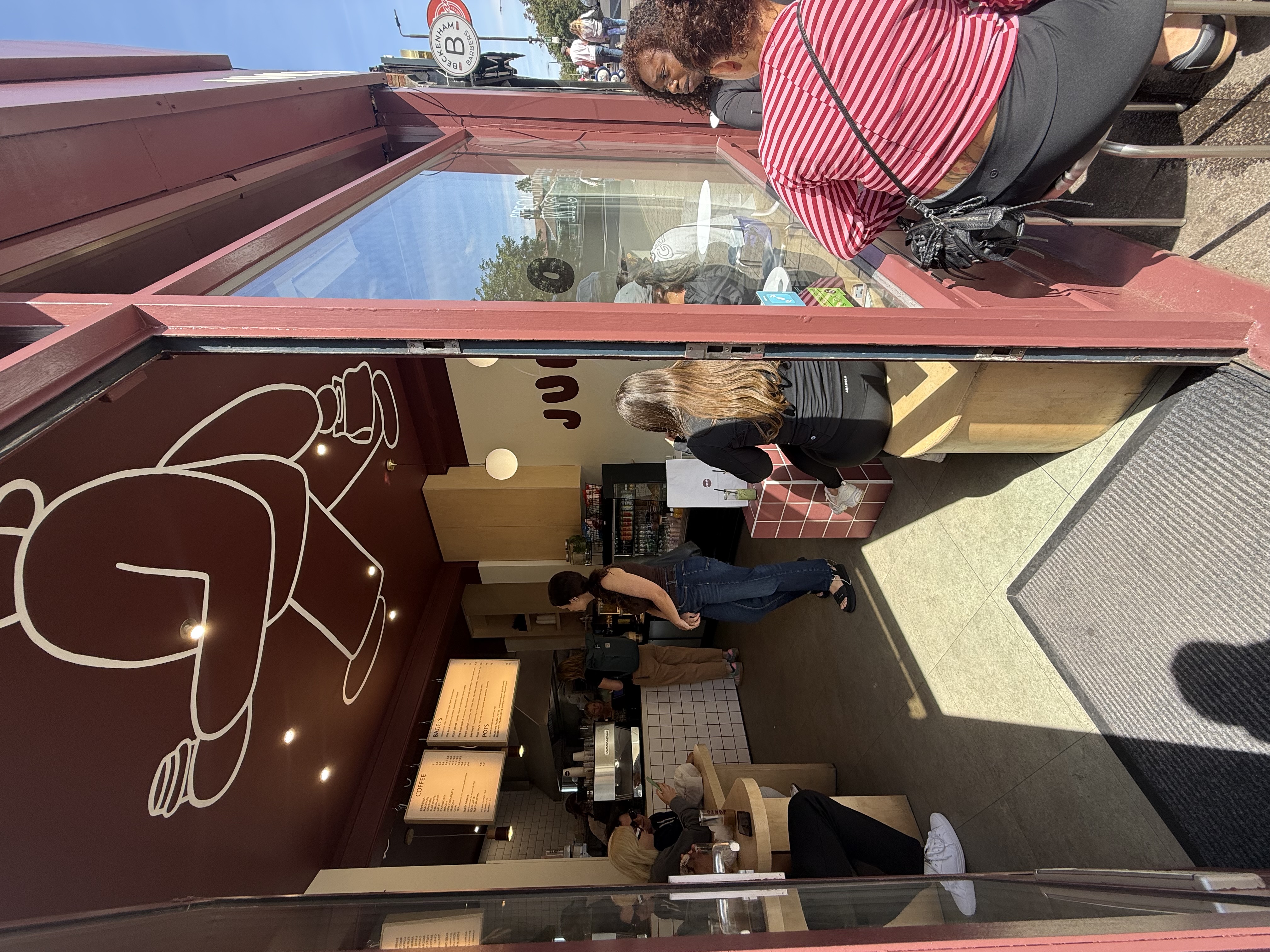 Inside Junto — the counter, the bear mural, pink tile and warm timber.